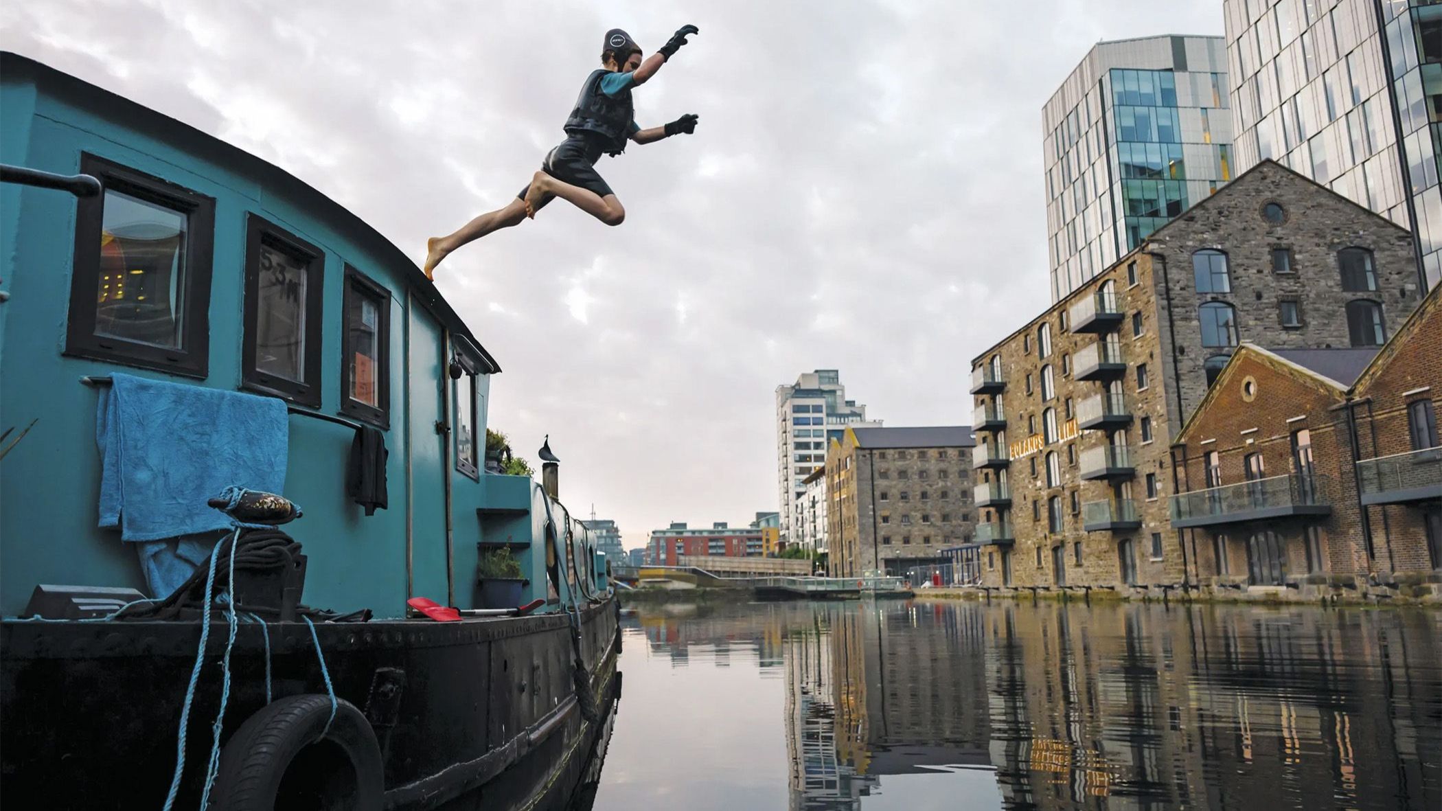 Person jumping from houseboat into canal in Dublin, Ireland Person jumping from houseboat into canal in Dublin, Ireland