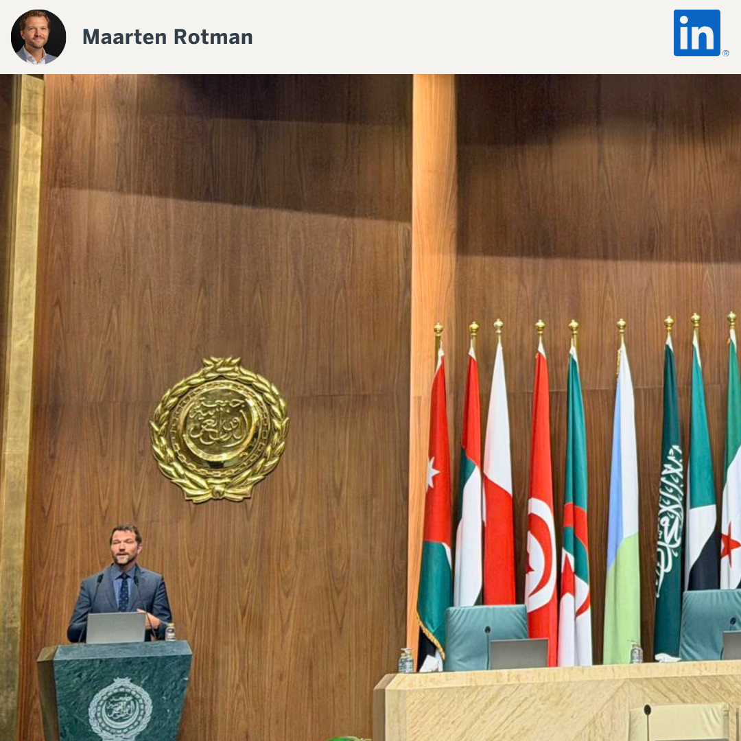 Speaker presenting with flags behind podium
